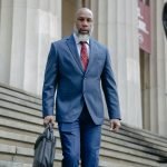 Successful black business man walking down stairs wearing a suit