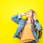 Happy woman laughing on bright yellow background